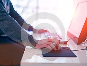 Male hand holding computer mouse with laptop keyboard