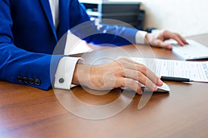 Male hand holding computer mouse with laptop