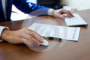 Male hand holding computer mouse with laptop