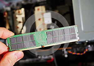 Male hand holding computer RAM DDR4 random access memory with computer