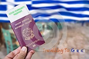 Male hand holding an european passport with a covid-19 immunity certificate over the Greek flag.