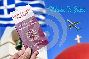 Male hand holding an european passport with a covid-19 immunity certificate over Santorini background.