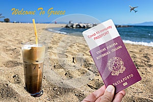 Male hand holding an european passport with a covid-19 immunity certificate over a frape coffee on the beach. photo