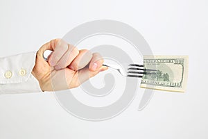 Male hand holding fork with money on white background
