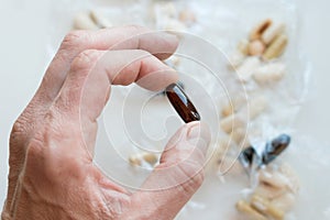 Male hand holding gelatin  bioactive dietary supplement pill