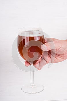 Male hand holding a glass of homemade craft beer on white background.  Ale or lager from pilsner malt