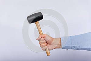 Male hand holding hammer on white background. Side view