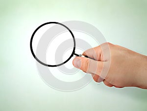 Male hand holding magnifying glass