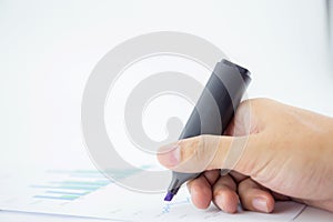 male hand holding marker over business document.