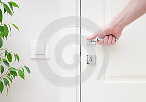 Male hand holding modern door handle. Close-up elements of the interior of the apartmen