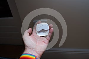 Male hand holding night light next to power outlet - ready to be plugged