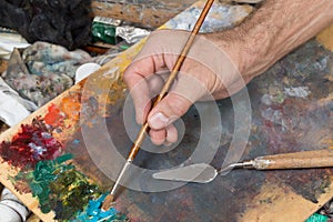 Male hand holding paint brush