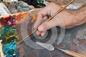 Male hand holding paint brush