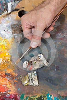 Male hand holding paint brush