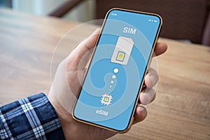 Male hand holding phone with Sim card replacement on eSim