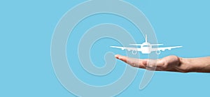 Male hand holding plane airplane icon on blue background. Banner.nline ticket purchase.Travel icons about travel planning,