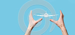 Male hand holding plane airplane icon on blue background. Banner.nline ticket purchase.Travel icons about travel planning,