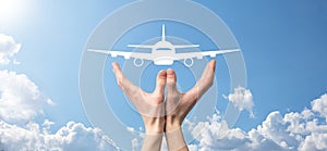 Male hand holding plane airplane icon on blue background. Banner.nline ticket purchase.Travel icons about travel planning,