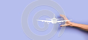 Male hand holding plane airplane icon on blue background. Banner.nline ticket purchase.Travel icons about travel planning,