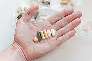 Male hand holding set of bioactive dietary supplement pills photo