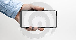 Male hand holding smartphone with blank screen horizontally. Take your screen to put on advertising