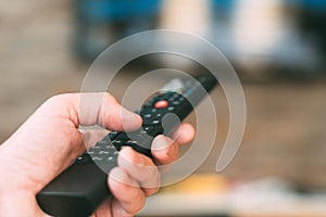 Male hand holding television remote controller