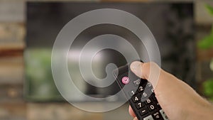 Male hand holding the TV remote control and turn OFF smart tv