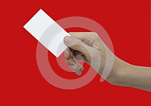 Male hand holding white card isolated on red background