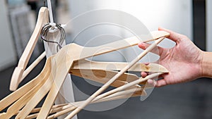 Male hand holding wooden clothes hanger