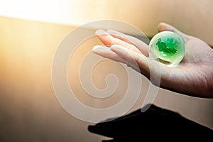 Male hand holding world globe crystal glass