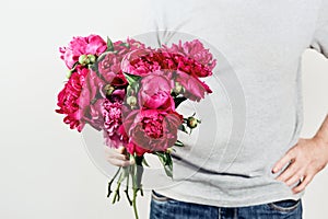 Male hand holds beautiful bouquet of white peonies. Flower delivery, gift, romantic concept