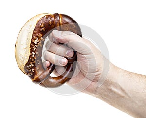 Male hand holds bretzel with salt isolated