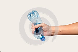 male hand holds and crushes a plastic bottle