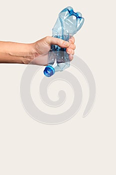 male hand holds and crushes a plastic bottle