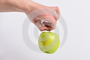 Male hand holds green apple. Apple fruit isolated on grey