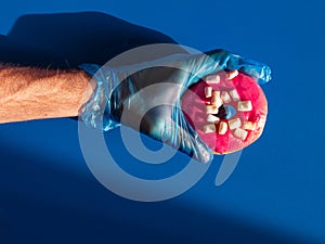 Male hand holds pink donut. Creative concept cervix cancer, uterus endometriosis, cervical erosion. Female health banner photo