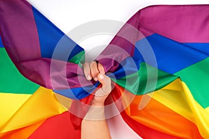 male hand holds a rainbow flag a symbol of the LGBT community