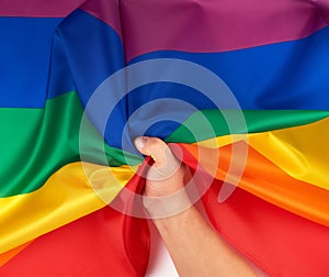 male hand holds a rainbow flag a symbol of the LGBT community