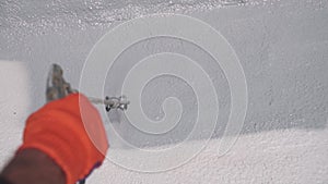 Male hand holds spray gun, uses chemical solution, paints the roof, insulates the roof