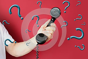 Male hand holds a telephone receiver Handset from vintage apparatus on red background, concept of anonymous psychological