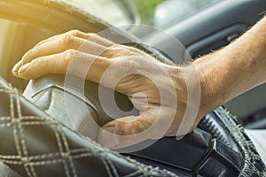 Male hand honking the car horn, man driving vehicle and beeping, front and back background blurred photo