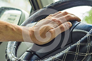 Male hand honking the car horn, man driving vehicle and beeping, front and back background blurred photo