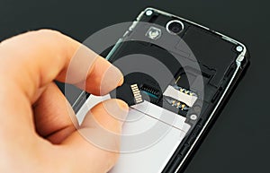 Male hand inserting Micro SD.