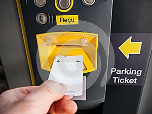 Male hand inserting parking ticket at electronic machine