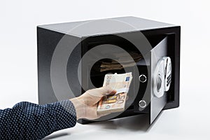 Male hand keeping euro banknotes in a safe deposit box