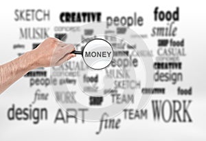 Male hand with magnifying glass and word 'money' in it over collage of terms