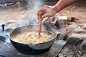 Male hand making holes in rice for boiling and vaporizing water. Rice pilaf cooking series photo