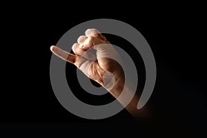 Male hand making pinky swear sign over dark background. The concept of friendship, quarrel, human relationships. copy photo