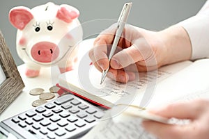 Male hand making some notes with silver pen on paper about cash flow