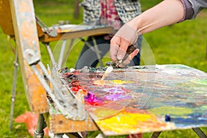 Male hand mixing light colors with a paletteknife photo